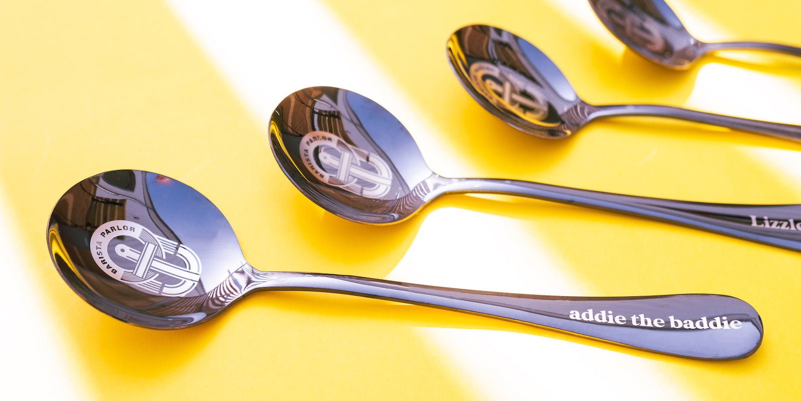 Umeshiso black spoon engraved with text and a logo